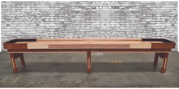 A wooden VG6134-SH shuffleboard table with a brick wall behind it.