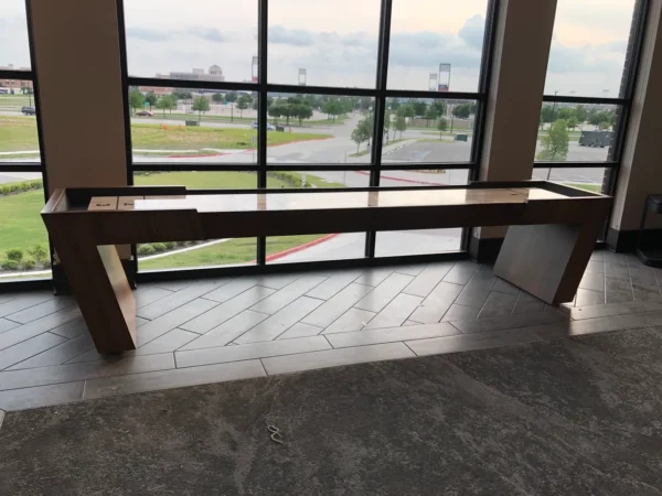 a Shuffleboard Table placed near a window
