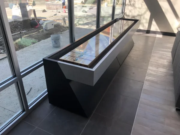 A table with a Item # CM6016-SH top in front of a window.