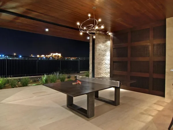 A ping pong table in a backyard at night.