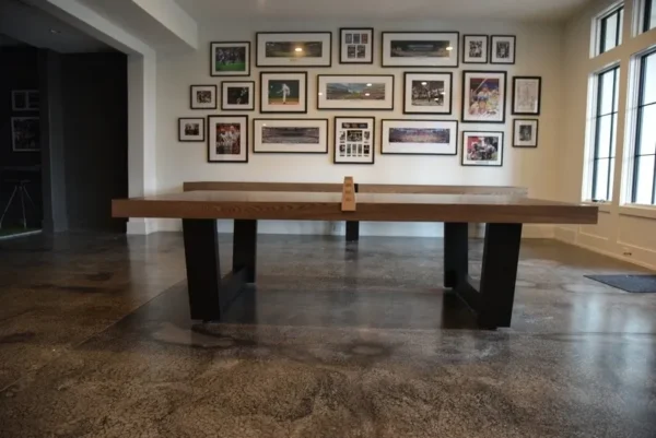 A room with a ping pong table and framed pictures.