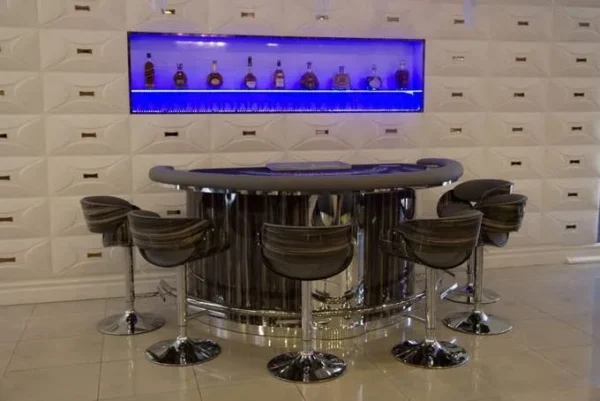 A modern bar with stools and a bottle of liquor.