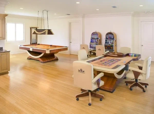 A game room with a pool table and chairs.