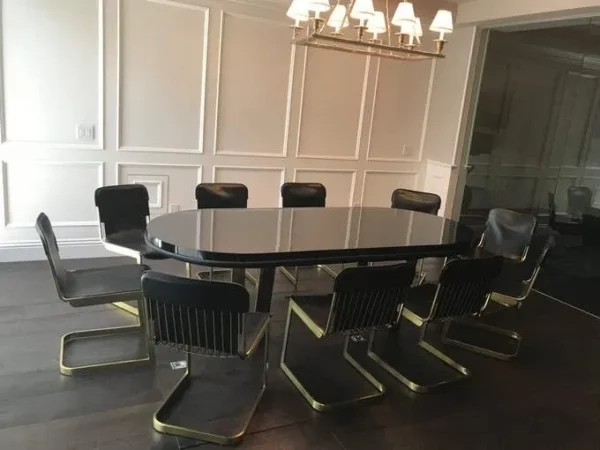 A dining table with black chairs and a chandelier.