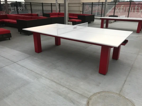A red ping pong table on a patio.