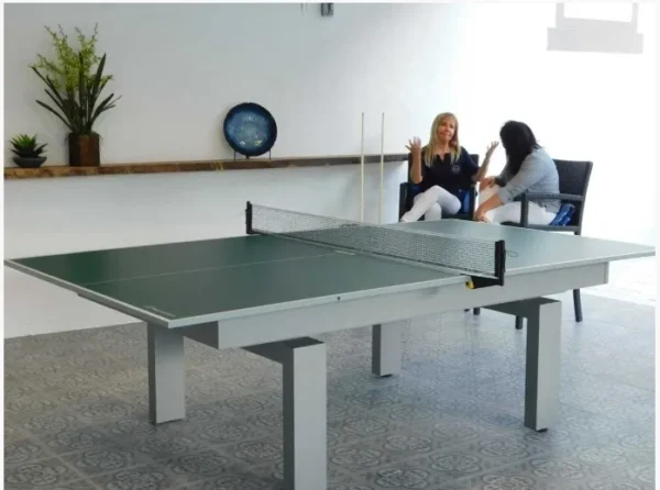 Two women playing ping pong in a room.