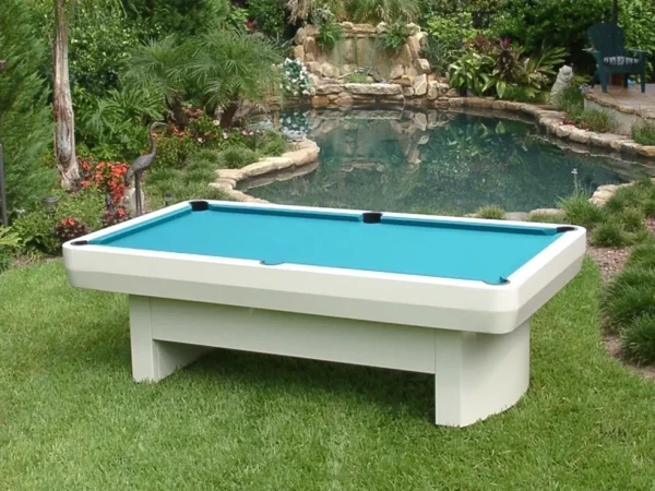 A pool table in a backyard with a pond.