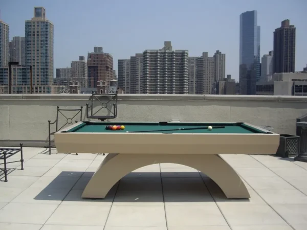 A pool table on a rooftop with a view of the city.