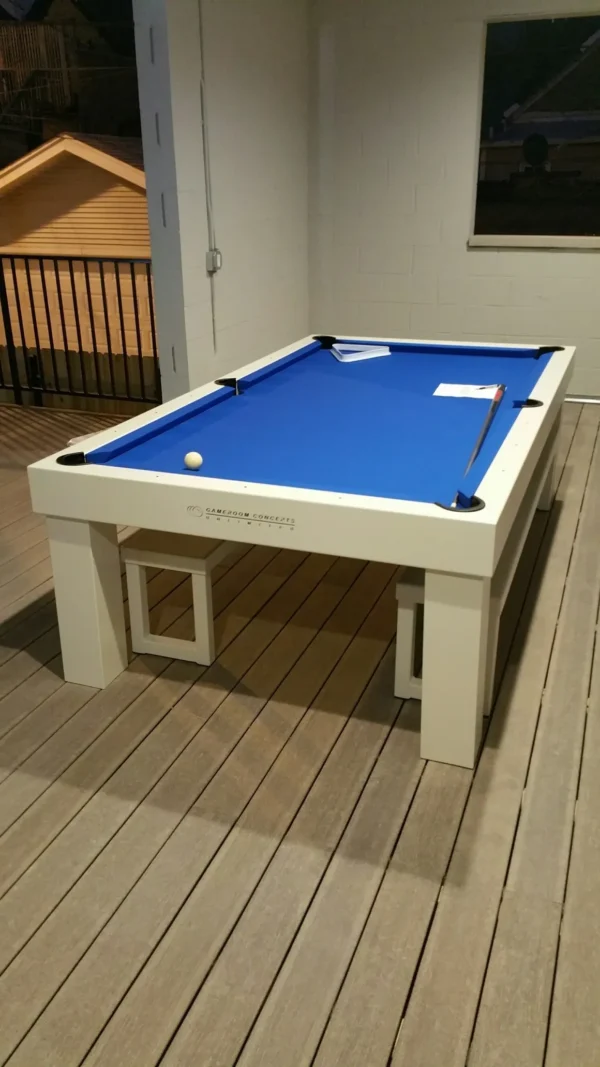 A pool table on a deck with a blue cloth.