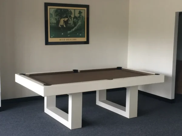 A pool table in a room with a picture on the wall.