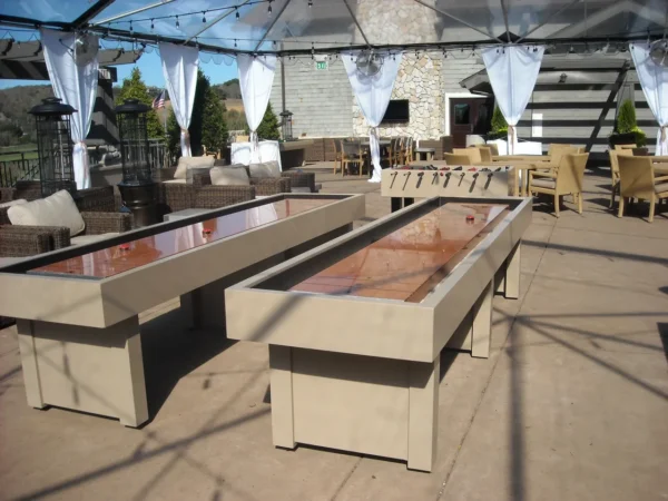 Shuffleboard tables on a patio under a tent.