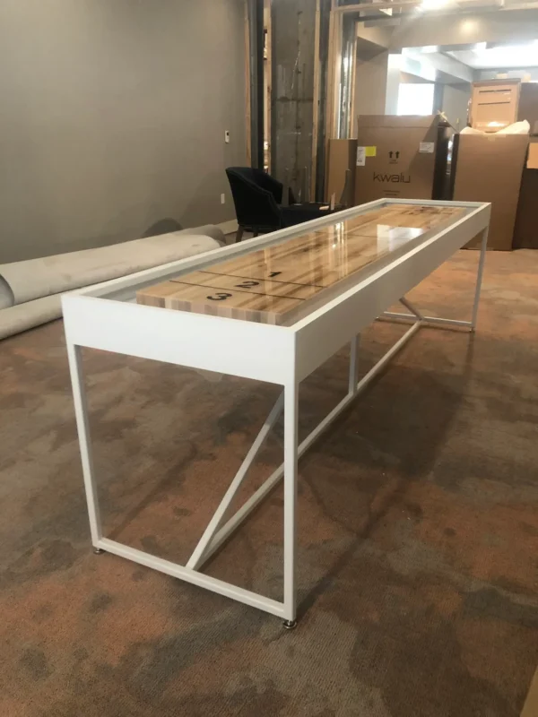 A white shuffleboard table in an empty room.