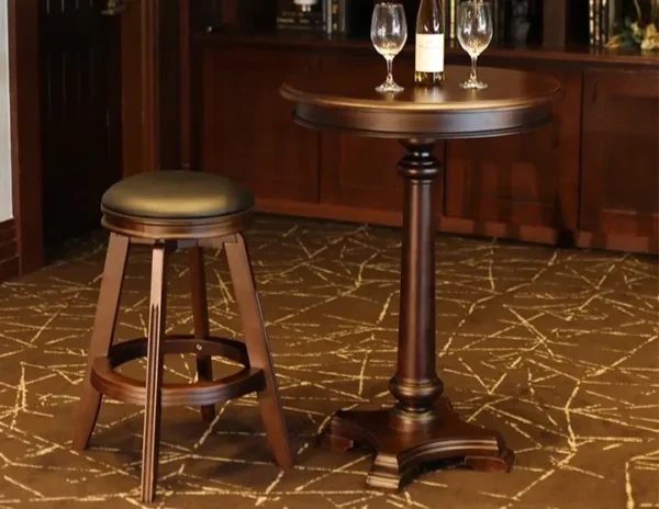 A bar table with two wine glasses and a bottle of wine.