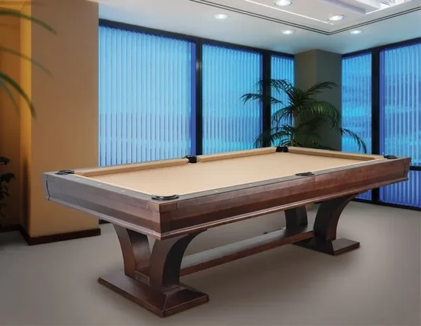A pool table in a room with large windows.