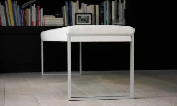 A white bench with a metal frame in front of the Item # FS13032-CH.