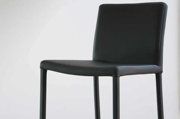 A Item # FS13030-CH leather bar stool against a white wall.