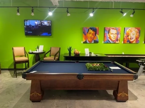 A green room with a pool table (Item # BR19060-AT) and chairs.
