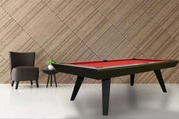 A modern Item # RR11046-OPT with a red felt top in a room with a patterned tan wall and a dark chair nearby.