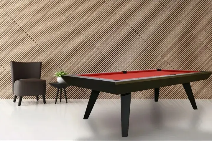 A modern Item # RR11046-OPT with a red felt top in a room with a patterned tan wall and a dark chair nearby.