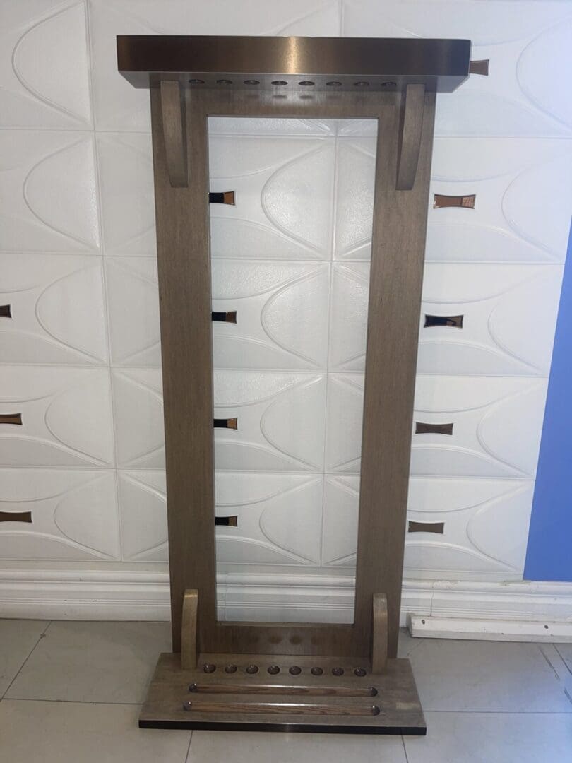 A Item # PH22032-CRW umbrella stand against a patterned white wall, featuring upper and lower shelves with symmetrical holes for holding umbrellas.