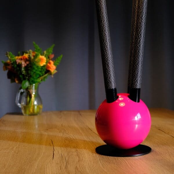 Pink orb lamp with black stems.